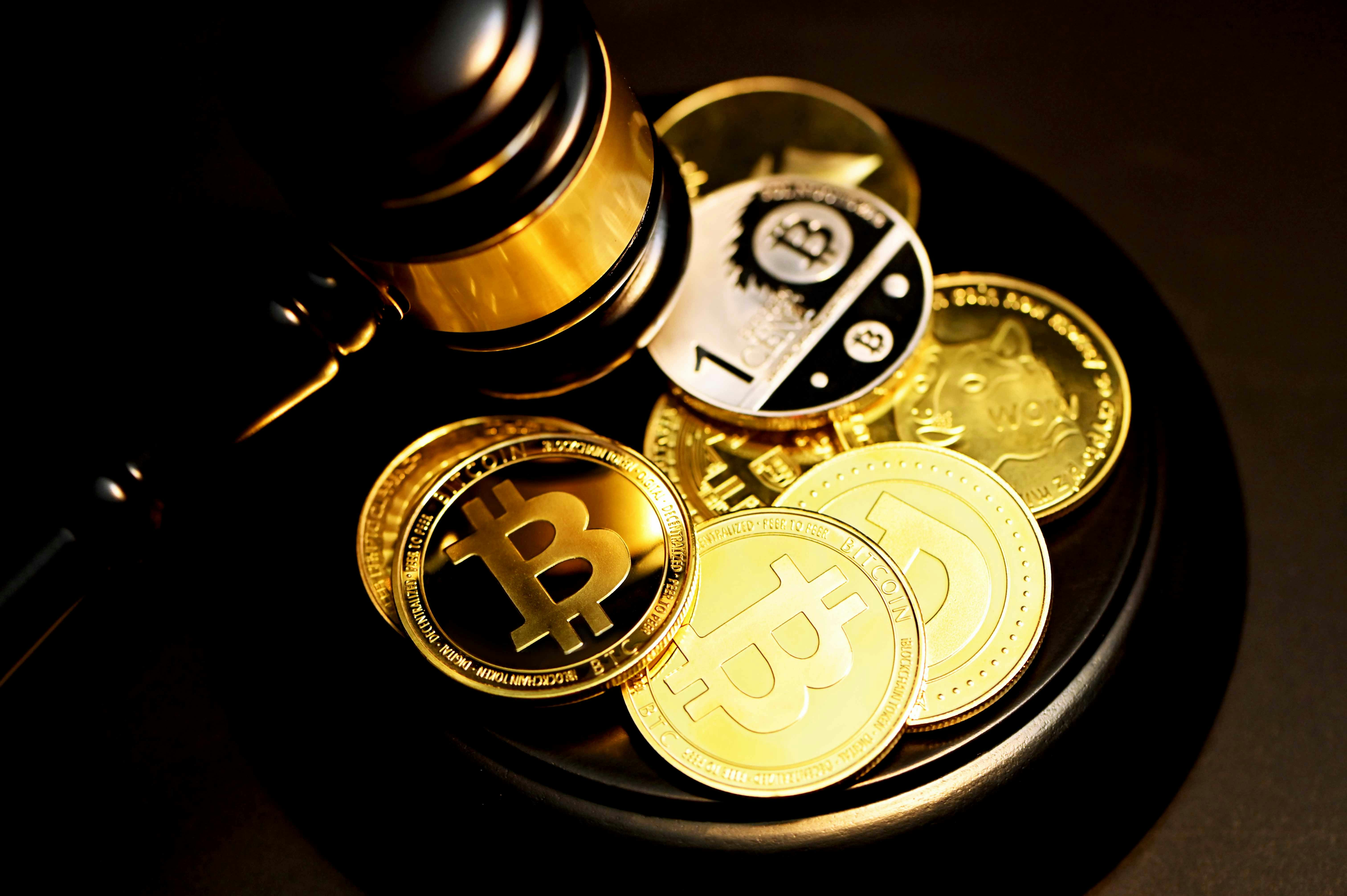 A pile of bitcoin coins next to a gavel