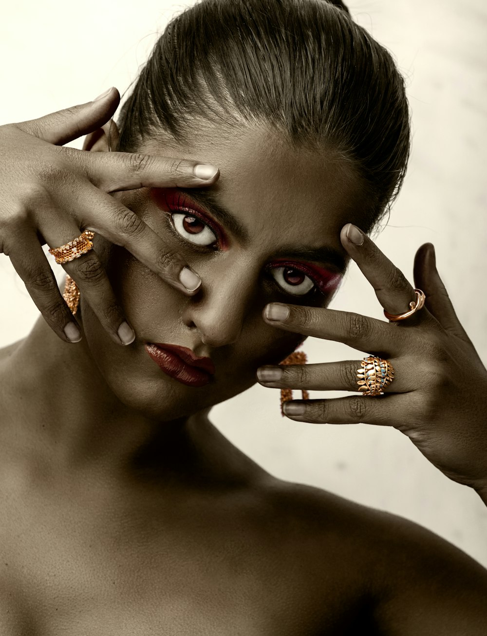 woman with red manicure wearing gold ring