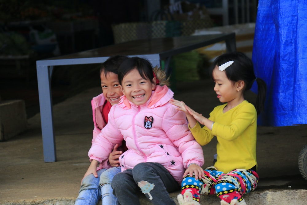 girl in pink jacket sitting beside girl in pink jacket