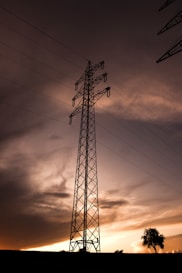 black electric tower under cloudy sky