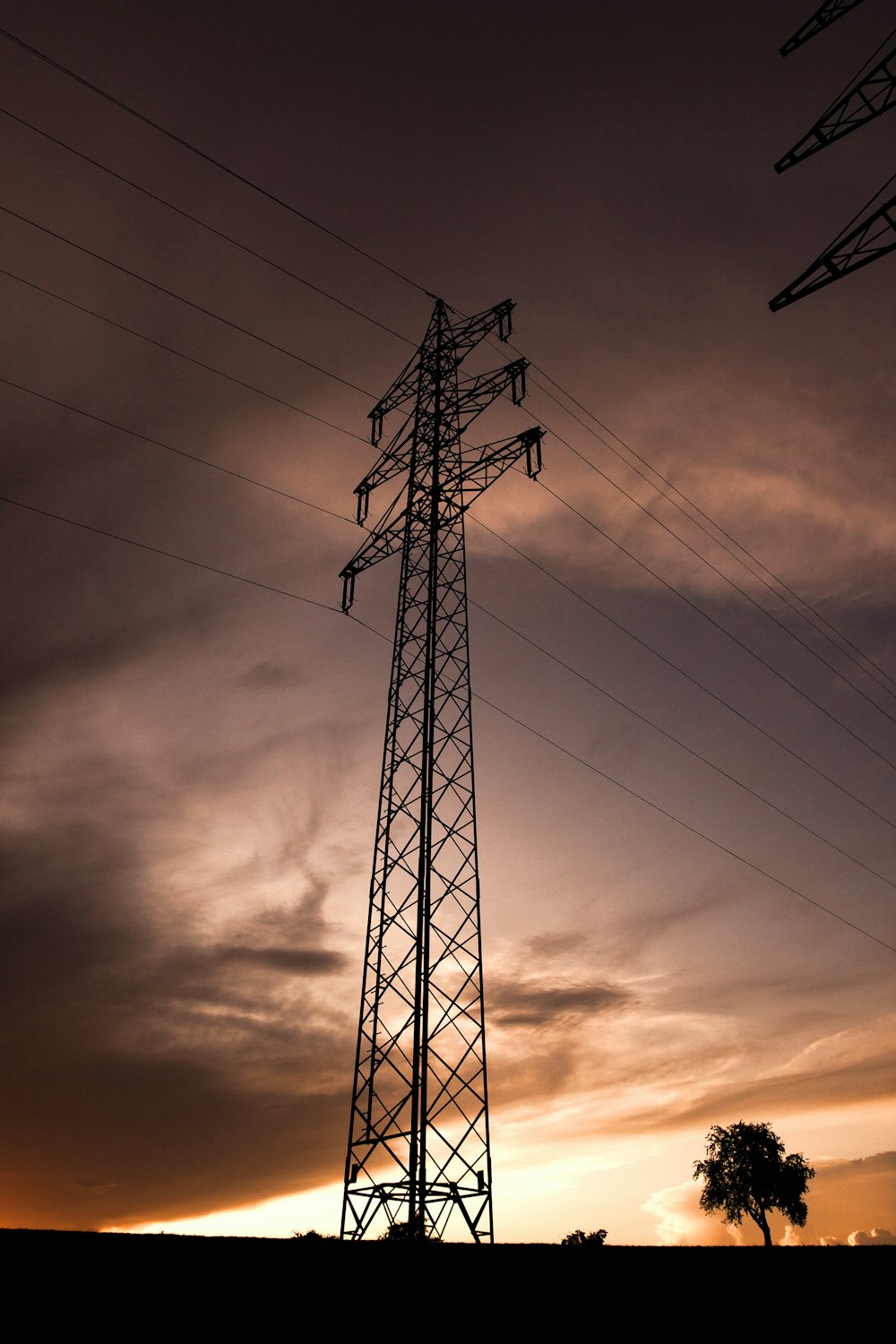 black electric tower under cloudy sky