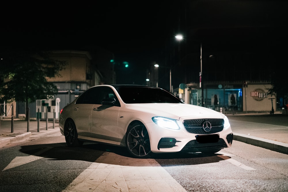 Mercedes Benz coupé blanc sur la route pendant la nuit