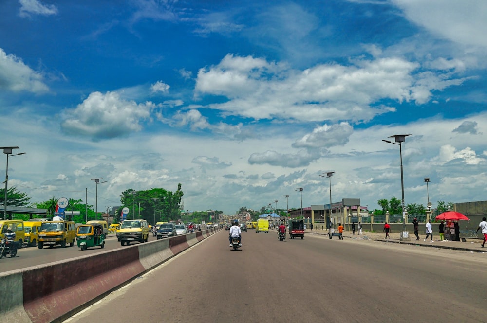 Autos unterwegs unter blauem Himmel und weißen Wolken tagsüber