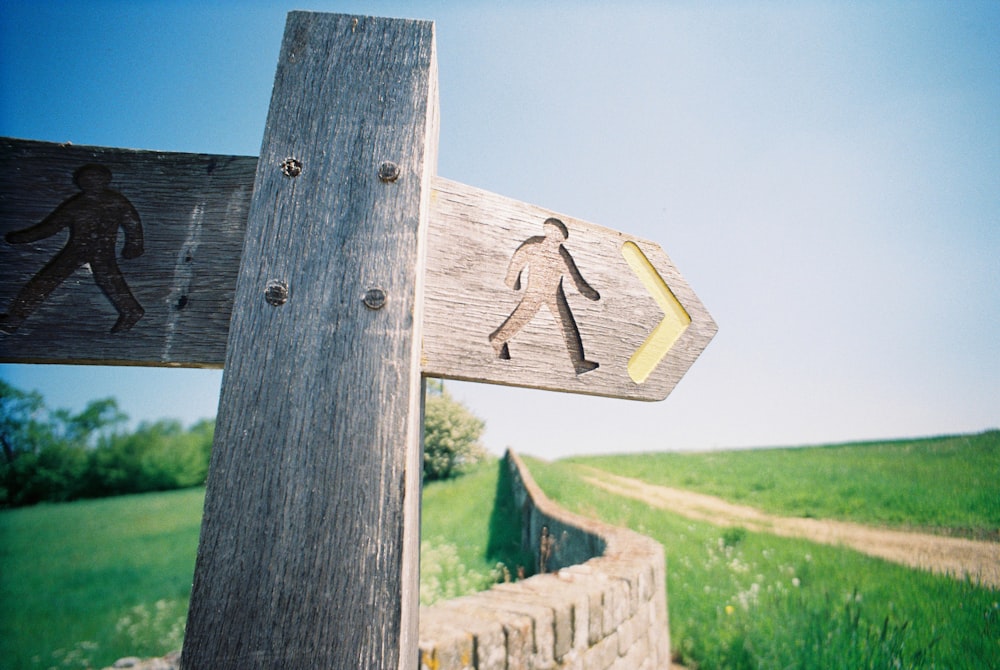 brown wooden cross with arrow sign