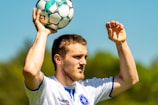 man in white nike soccer jersey holding soccer ball
