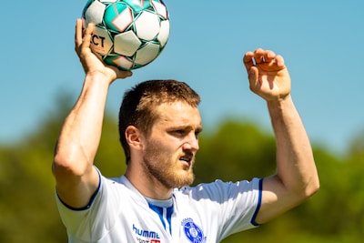 man in white nike soccer jersey holding soccer ball