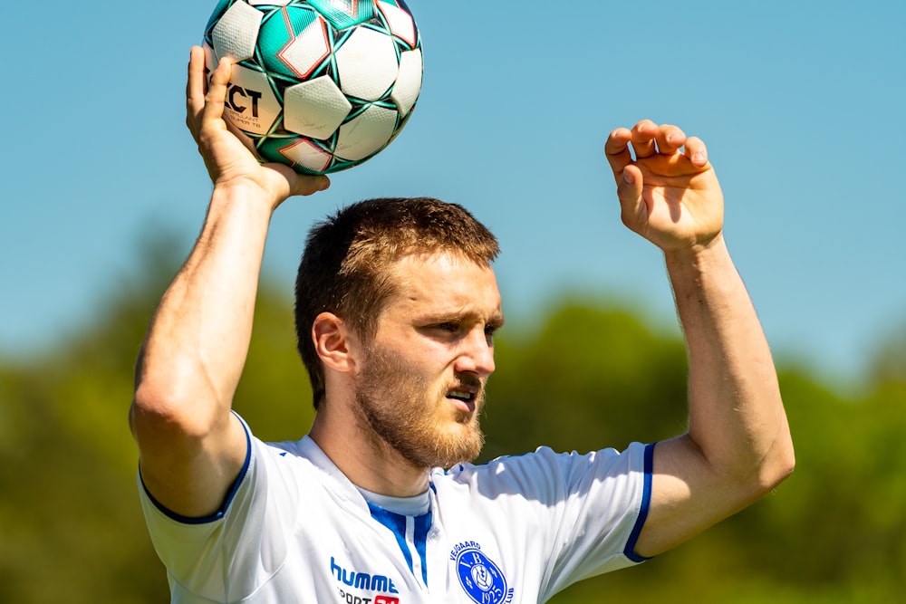 man in white nike soccer jersey holding soccer ball