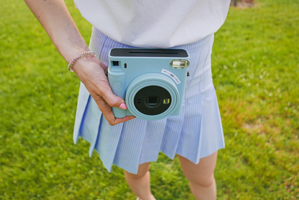 woman in white shirt holding silver and black camera