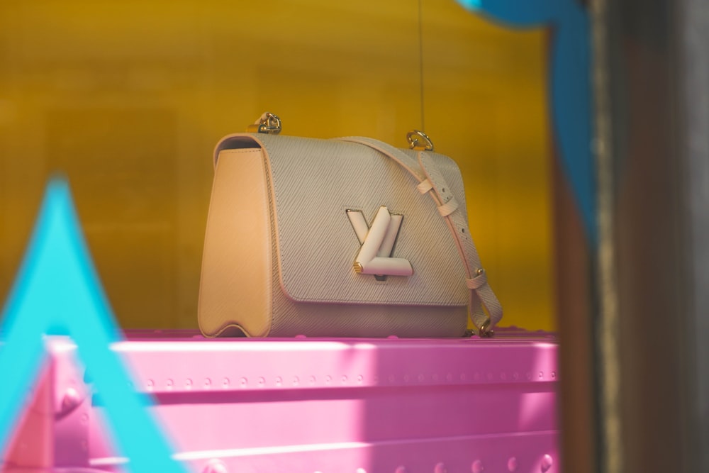 brown leather handbag on pink plastic drawer