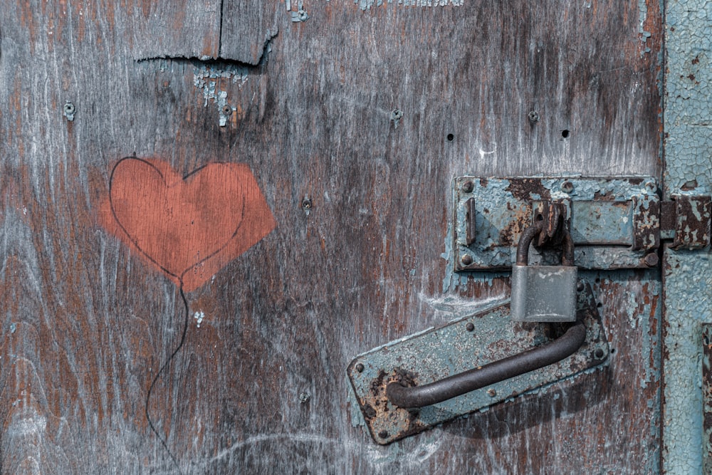 gray metal padlock on brown wooden door