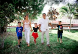A group of diverse fathers and children holding hands in a park, symbolizing unity and restoration.