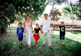 A multi-generational family walking together in a sunlit park