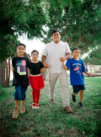 Cristian León interacting with local families in an outdoor green environment.