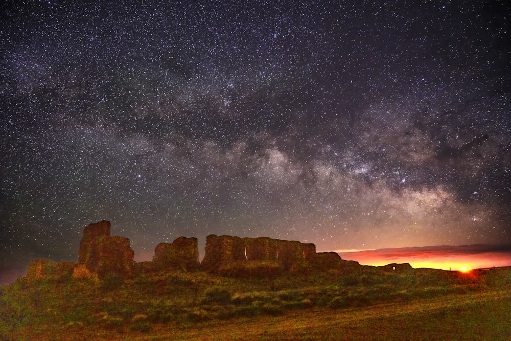 brown rock formation under starry night