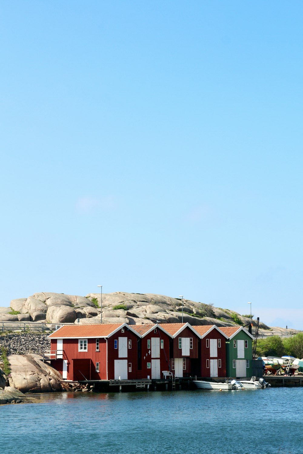 Casas rojas y verdes cerca de la montaña bajo el cielo azul durante el día