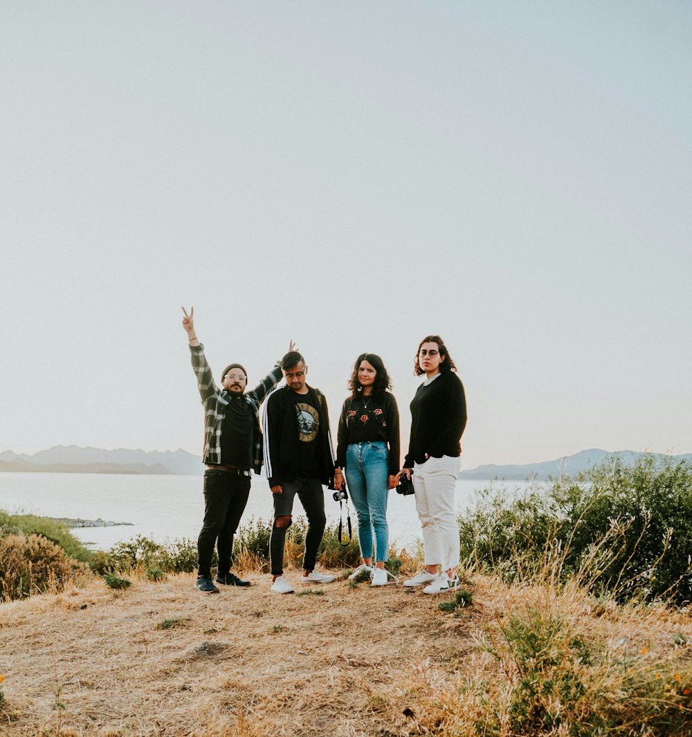 group of people standing on brown field during daytime