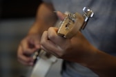 person playing brown guitar during daytime