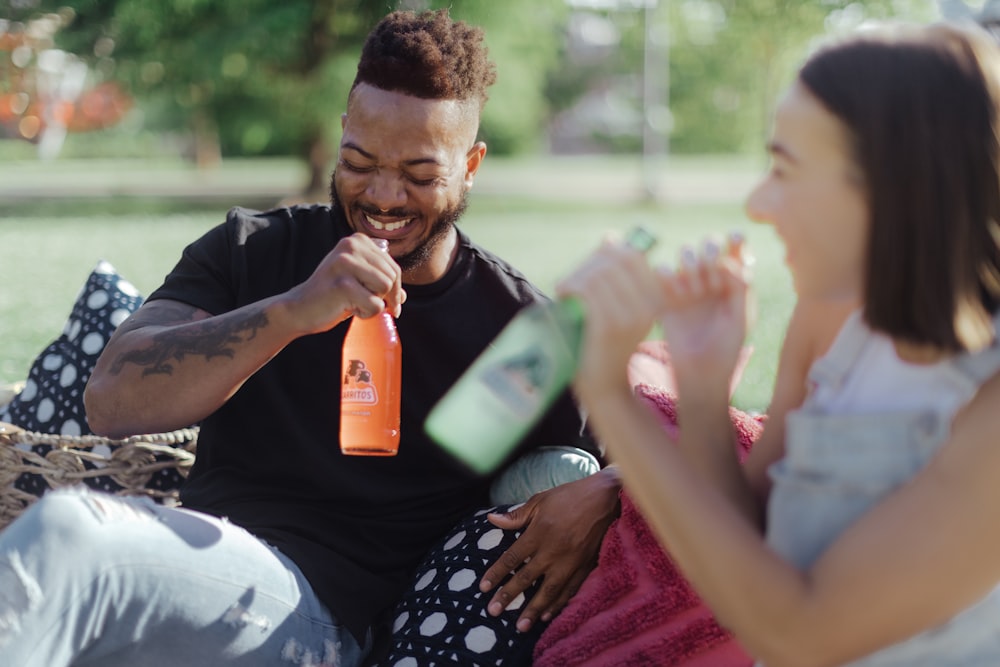 man in black and white polka dot shirt holding orange plastic cup