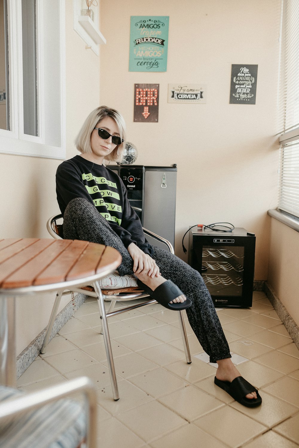 woman in black and white scarf and black pants sitting on white folding chair