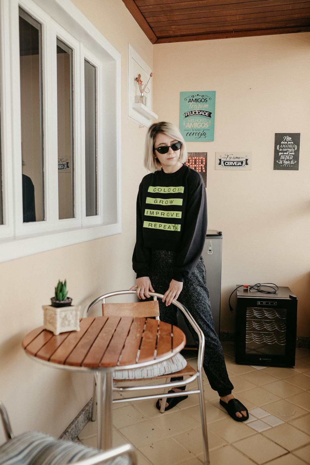 woman in black long sleeve shirt standing beside brown wooden table