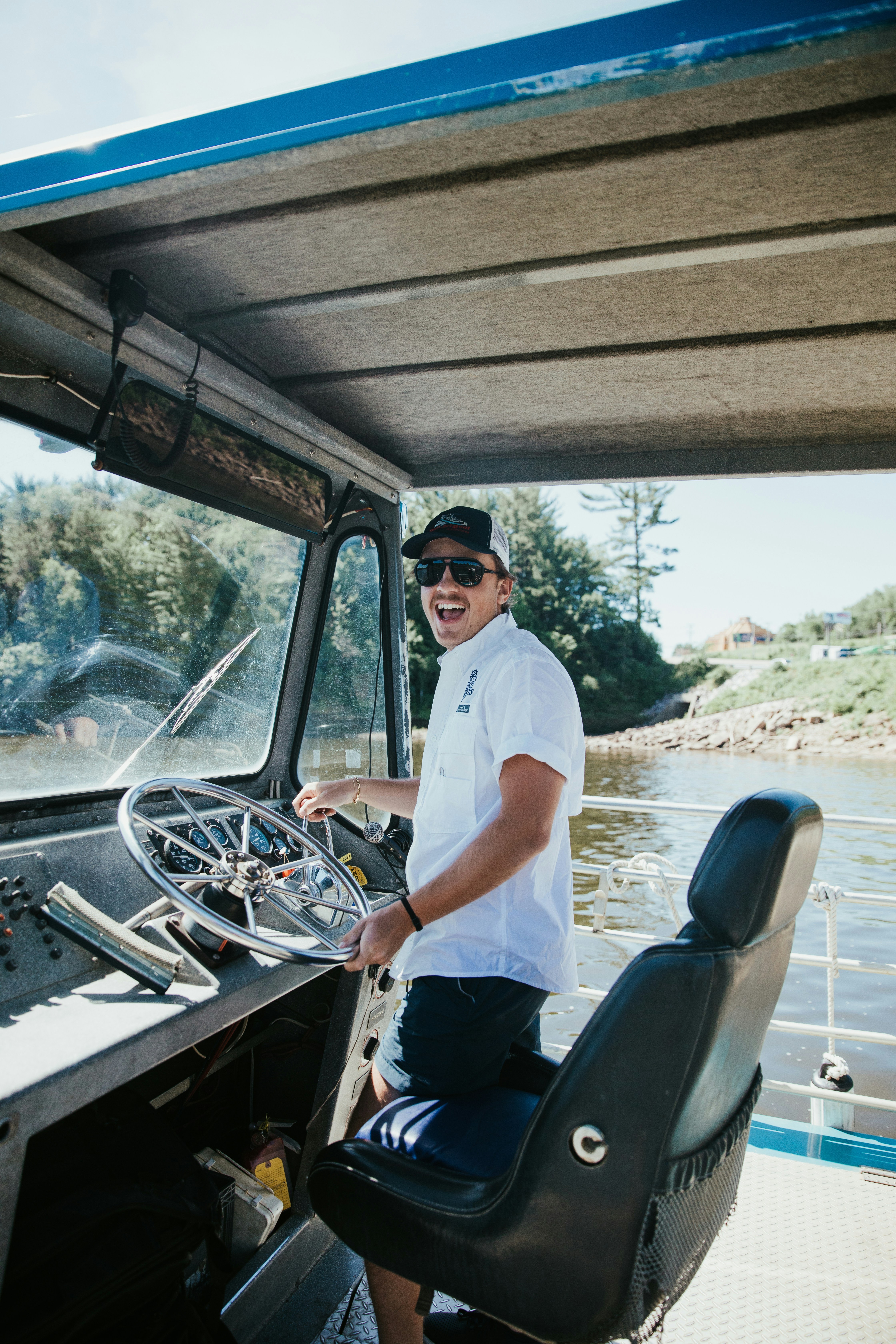 man in white button up t-shirt and blue denim jeans sitting on black car