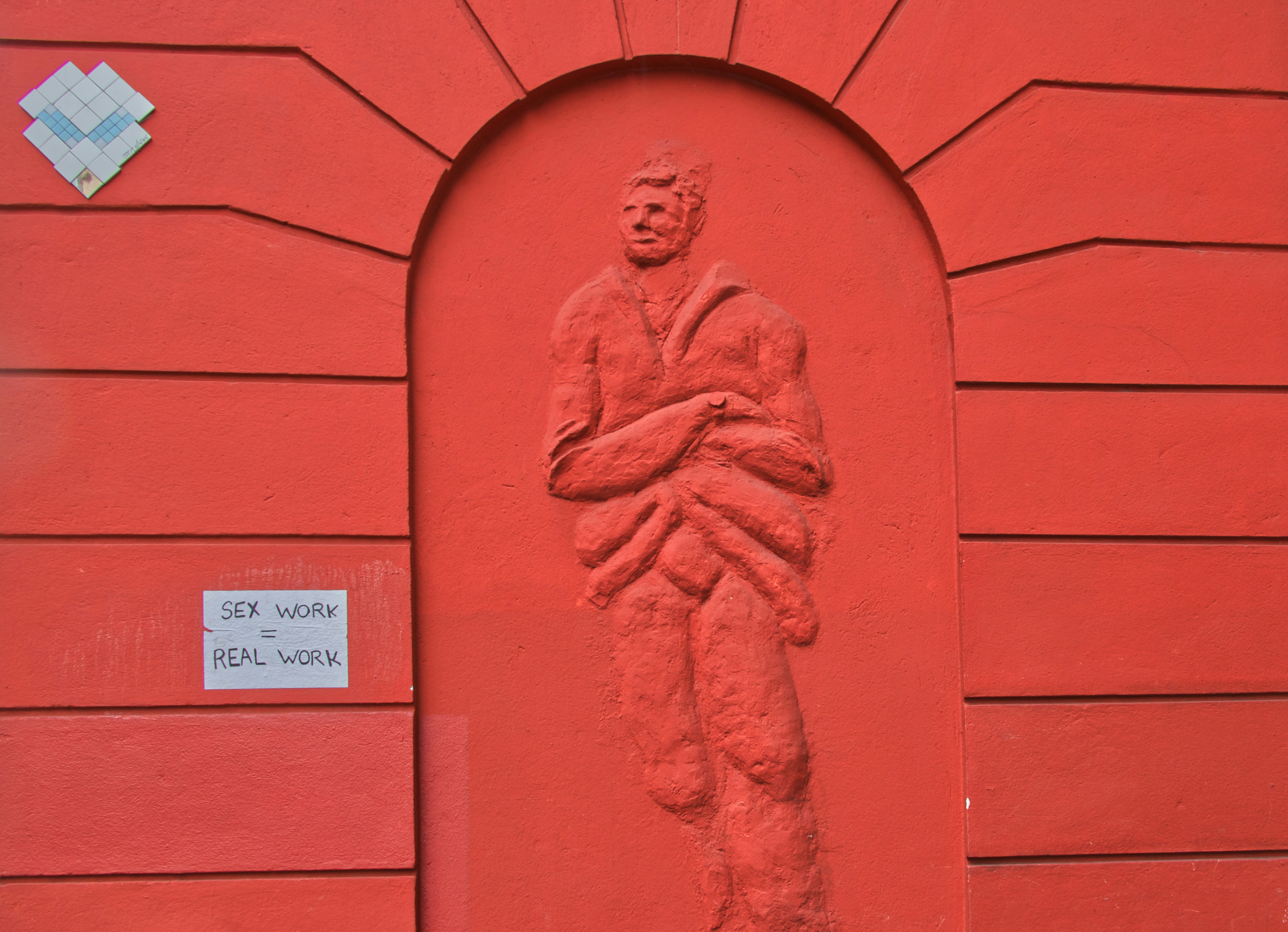 red concrete wall with mans face carved