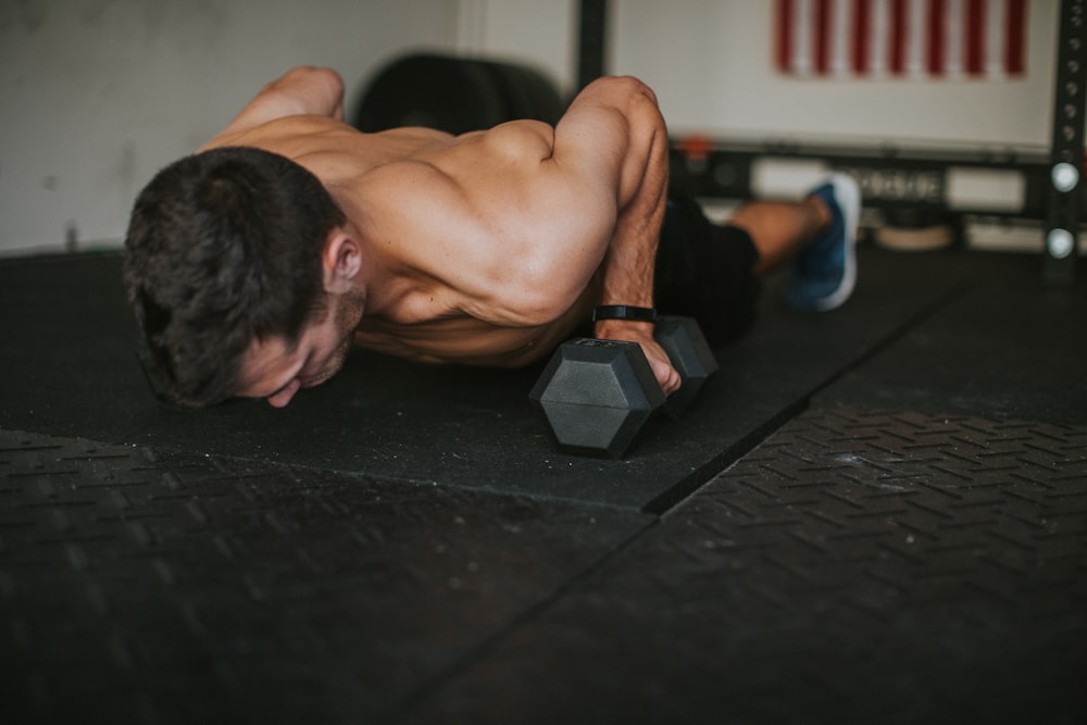 topless man lying on black floor