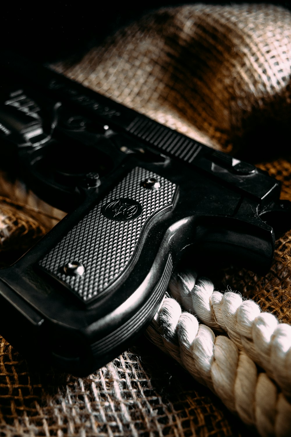Pistolet semi-automatique noir sur textile marron