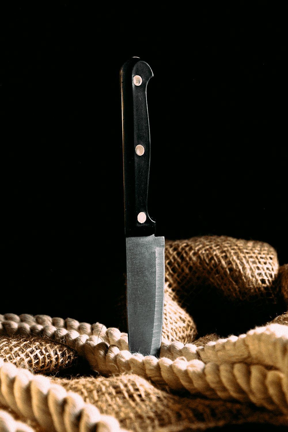black handle knife on brown woven round basket