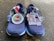 A pair of navy blue running shoes is placed on an asphalt surface. Two medals are resting on the shoes. One medal features a colorful maple leaf design with the text 'Course Virtuelle Canada Day Virtual Run.' The other medal is shaped like a map of Canada with provinces labeled and 'Canada Day' written across it.