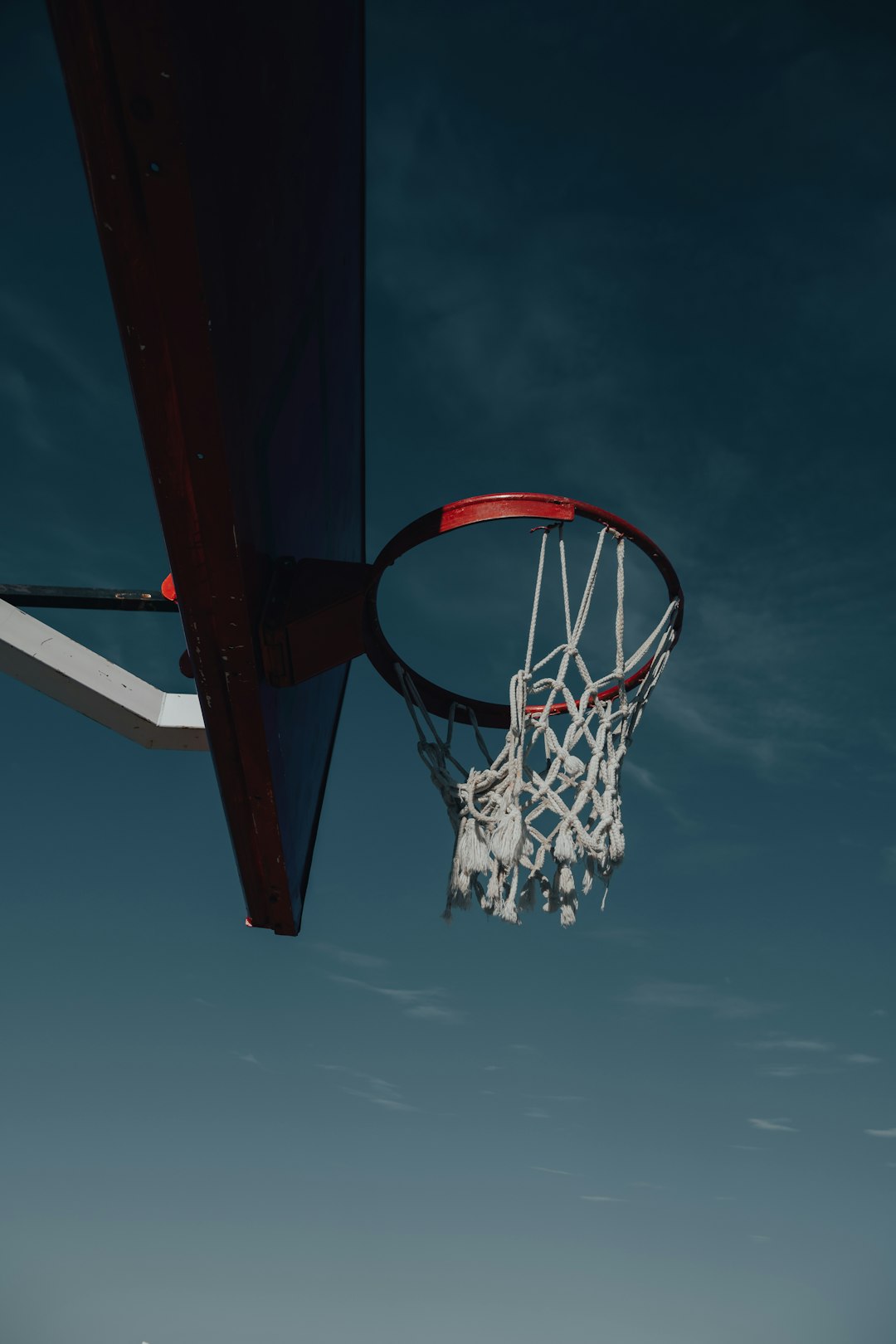 red and white basketball hoop under blue sky