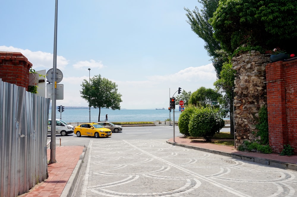 yellow car on road near body of water during daytime