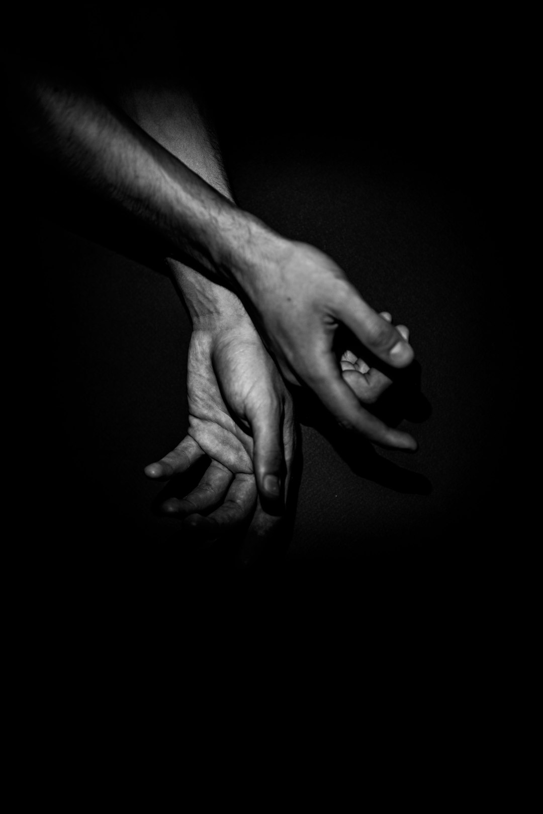 grayscale photo of 2 hands holding each others hand