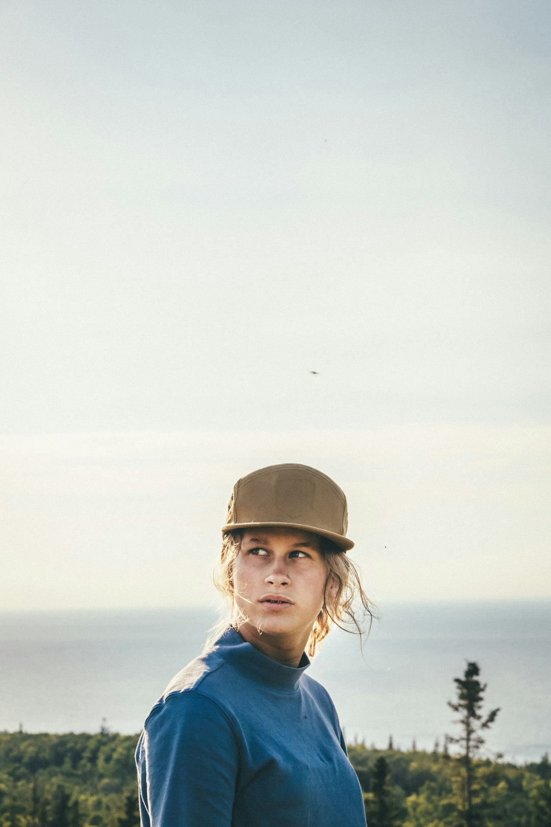 man in blue and white jacket wearing brown hat