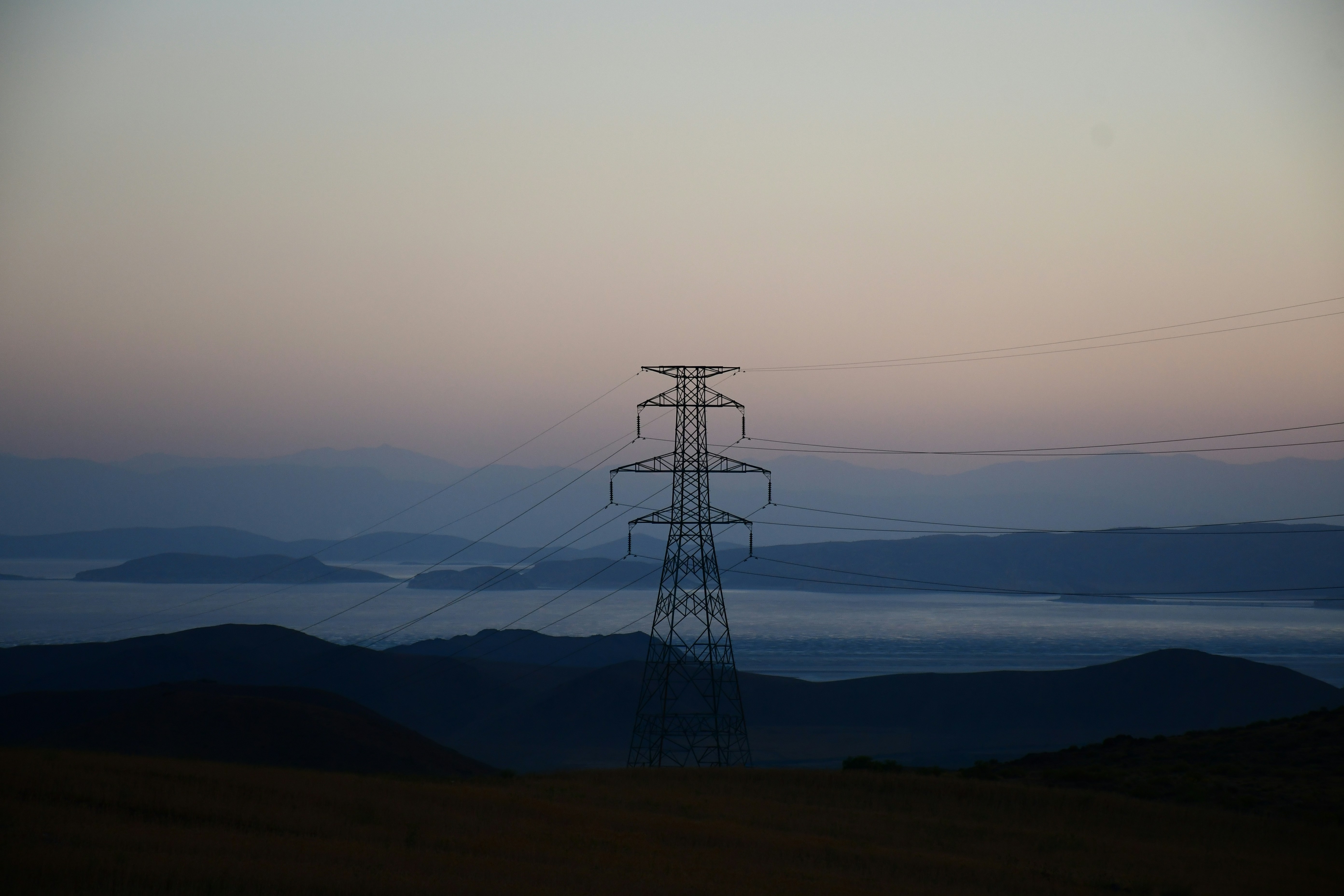 black electric tower on brown field during daytime