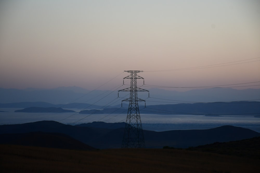 black electric tower on brown field during daytime