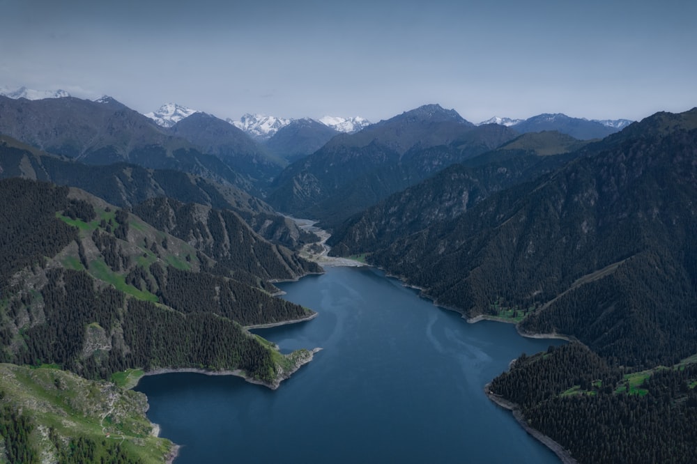 lago verde cercado por montanhas durante o dia