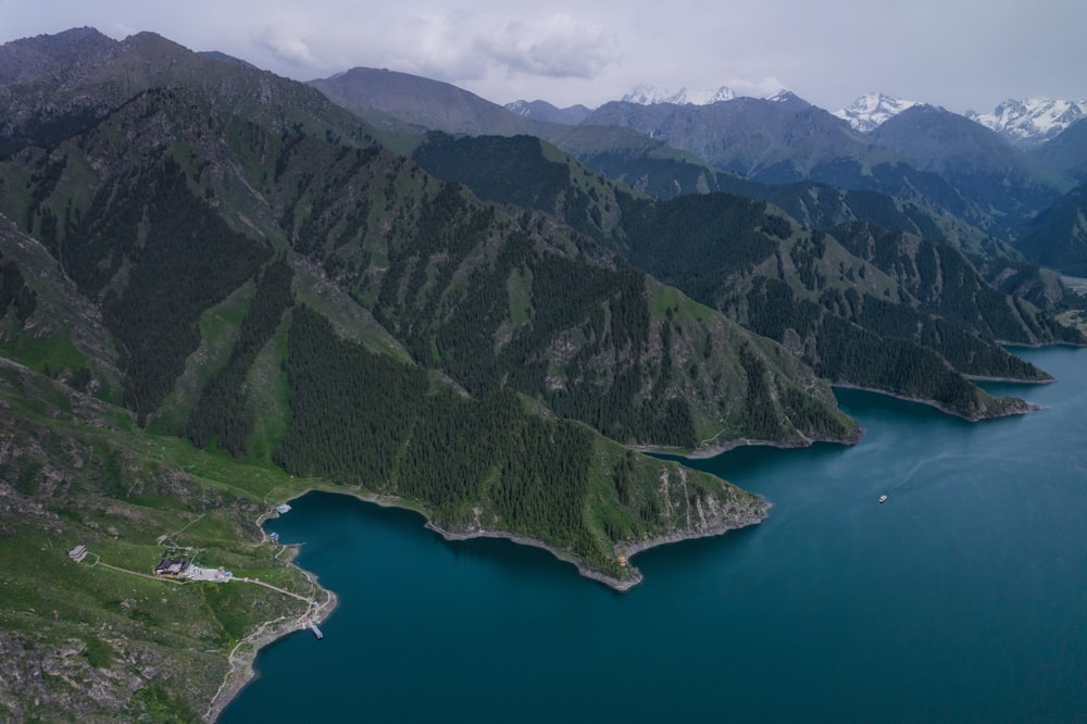 green and gray mountains beside blue sea during daytime