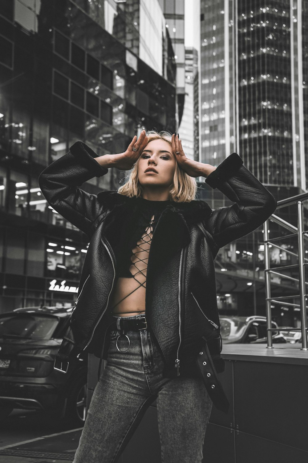 woman in black leather jacket covering her face with her hands