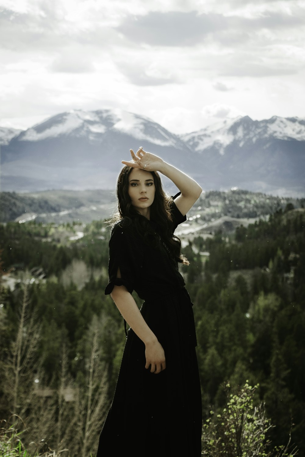 woman in black dress standing on green grass field during daytime