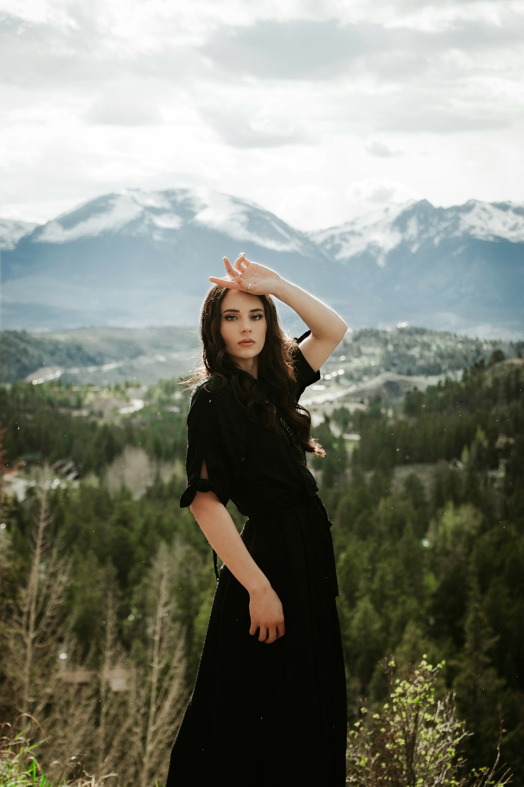 woman in black dress standing on green grass field during daytime