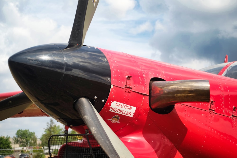 rotes und schwarzes Flugzeug tagsüber unter blauem Himmel