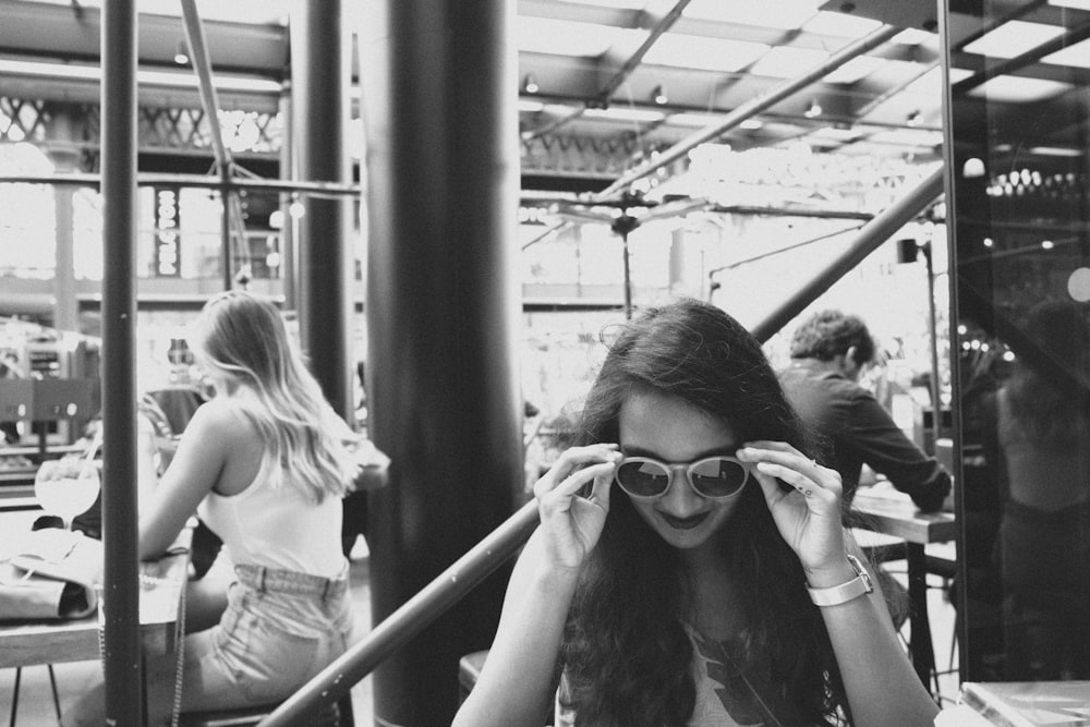 woman in white tank top wearing black framed eyeglasses