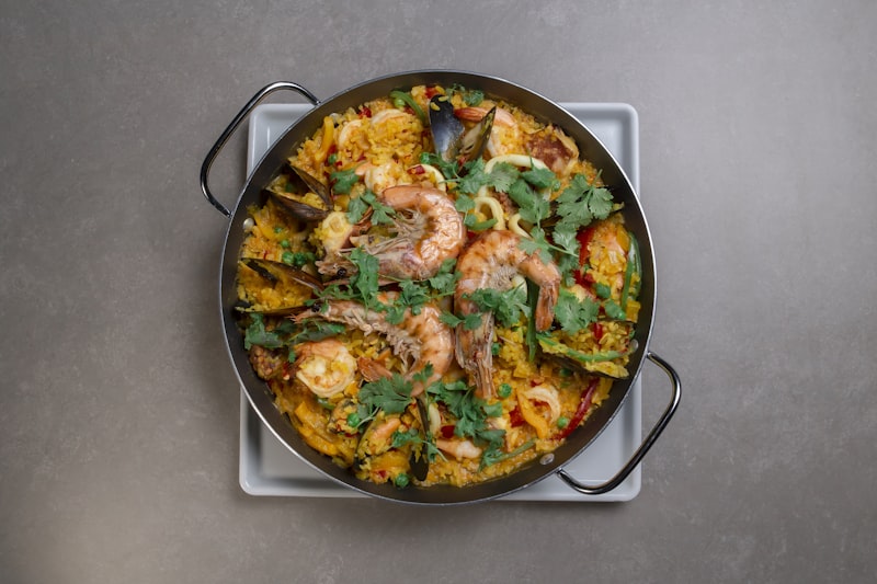 Wide pan of saffron seafood with prawns, mussels and fresh herbs