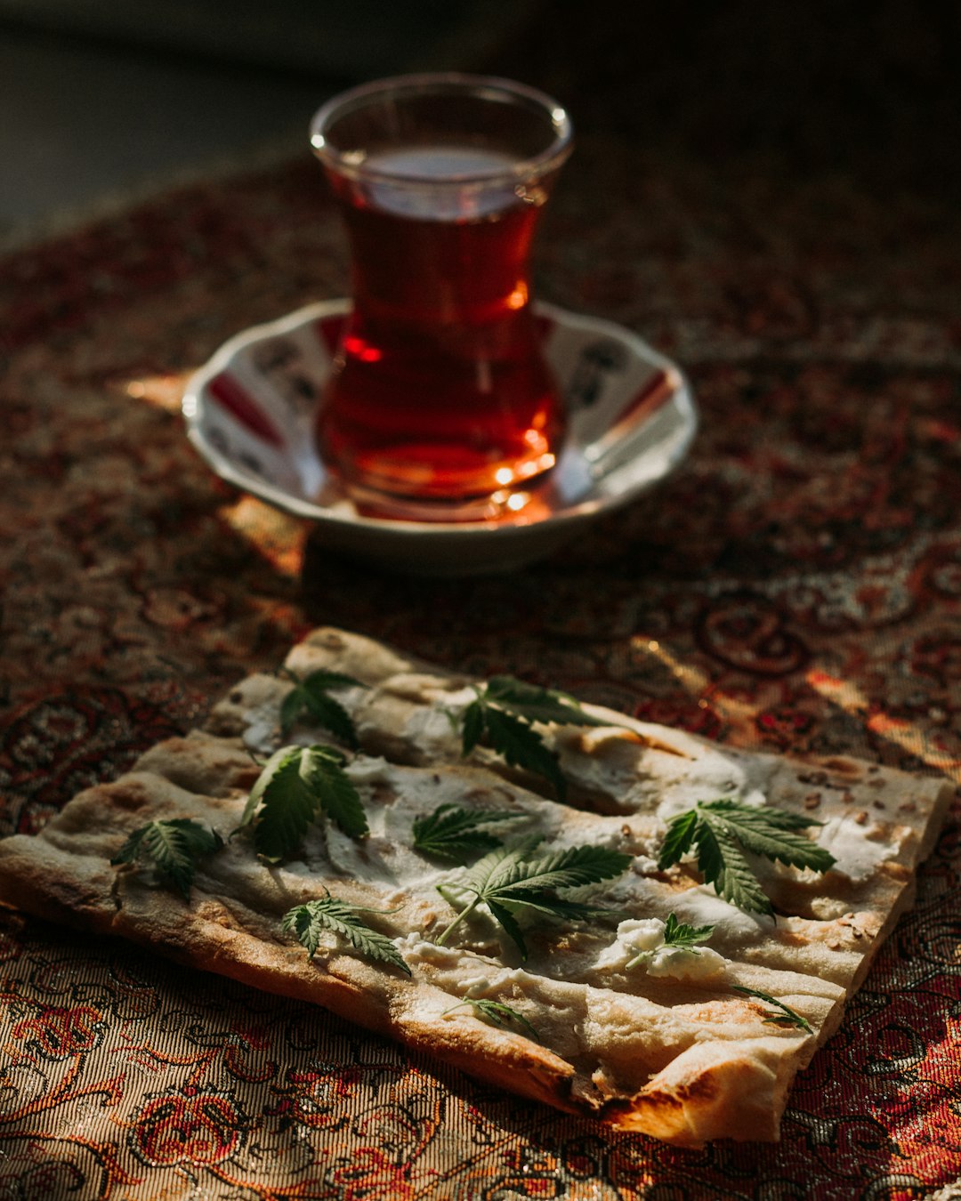 clear glass mug with red liquid on brown and green floral tray