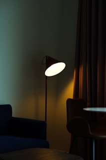 A modern floor lamp illuminating a cozy reading nook.
