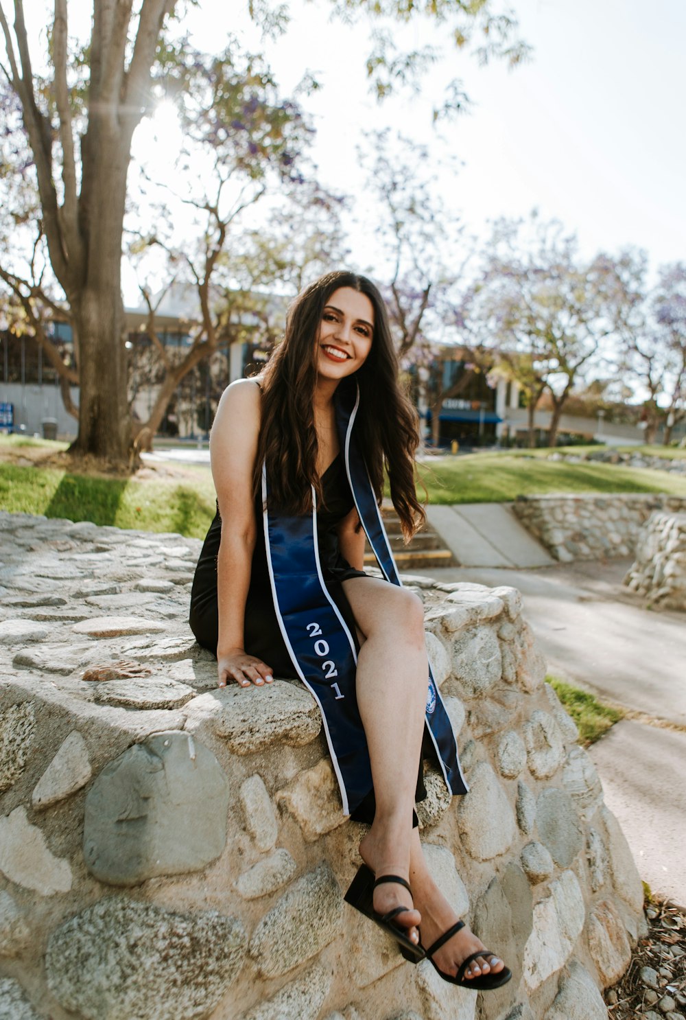 woman in blue tank top and black pants sitting on gray concrete bench during daytime