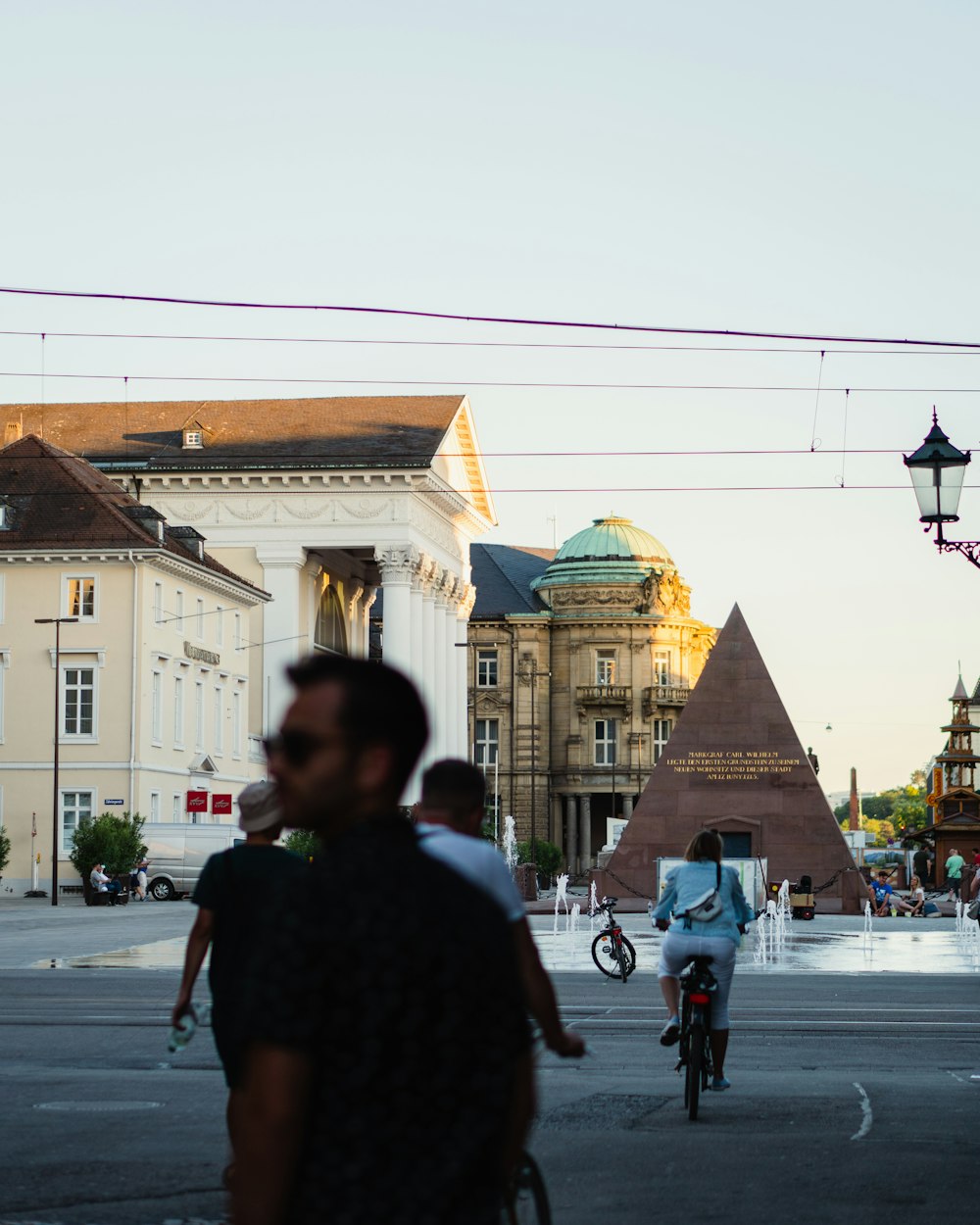 homme en chemise noire debout sur le trottoir pendant la journée