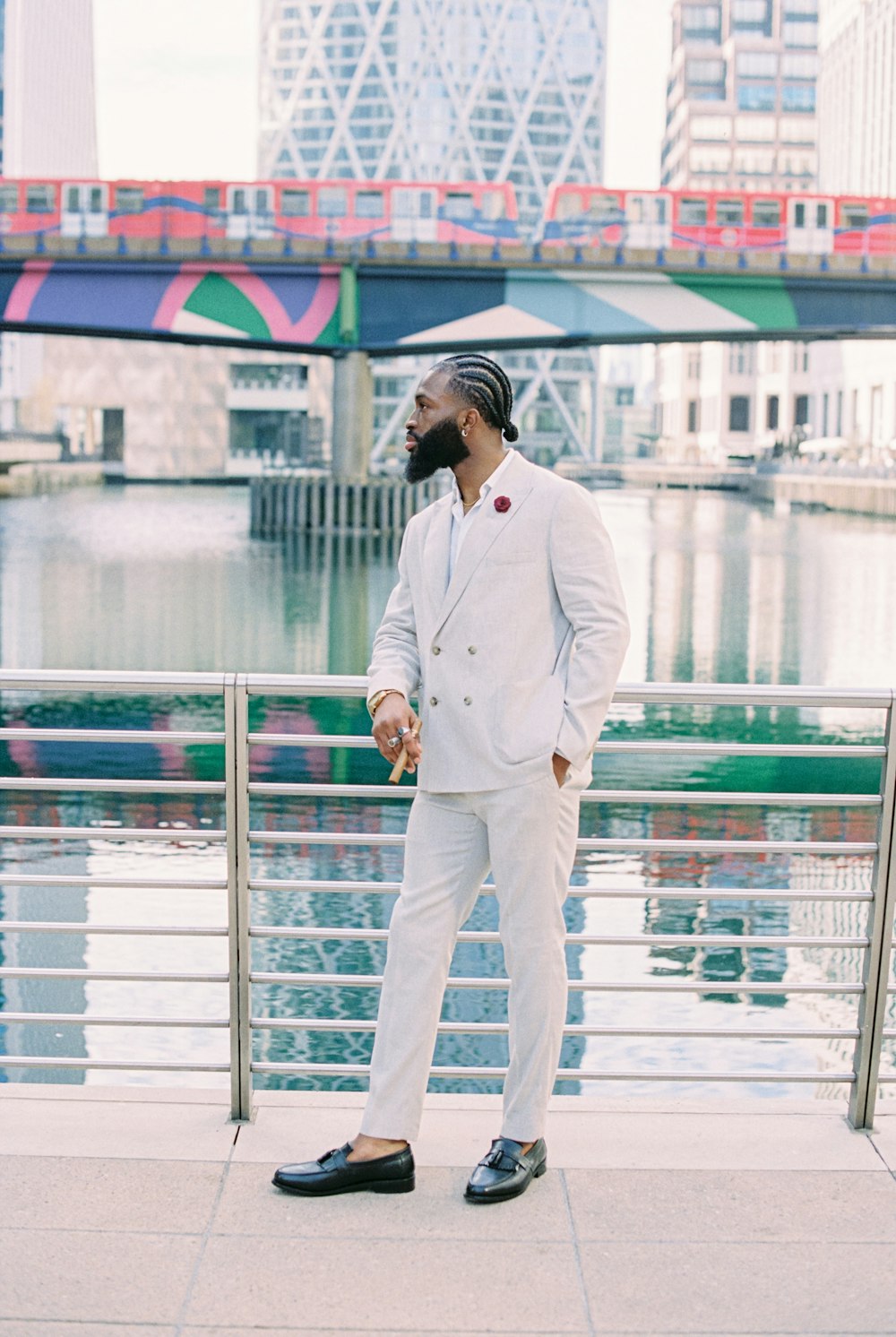 man in white suit standing beside blue metal railings