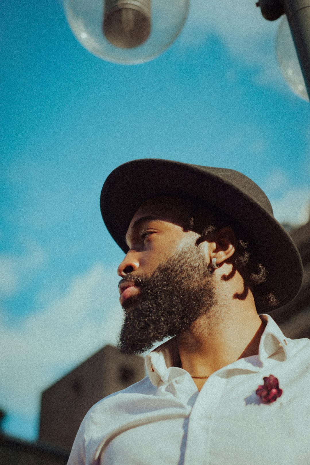 man in white collared shirt wearing black hat